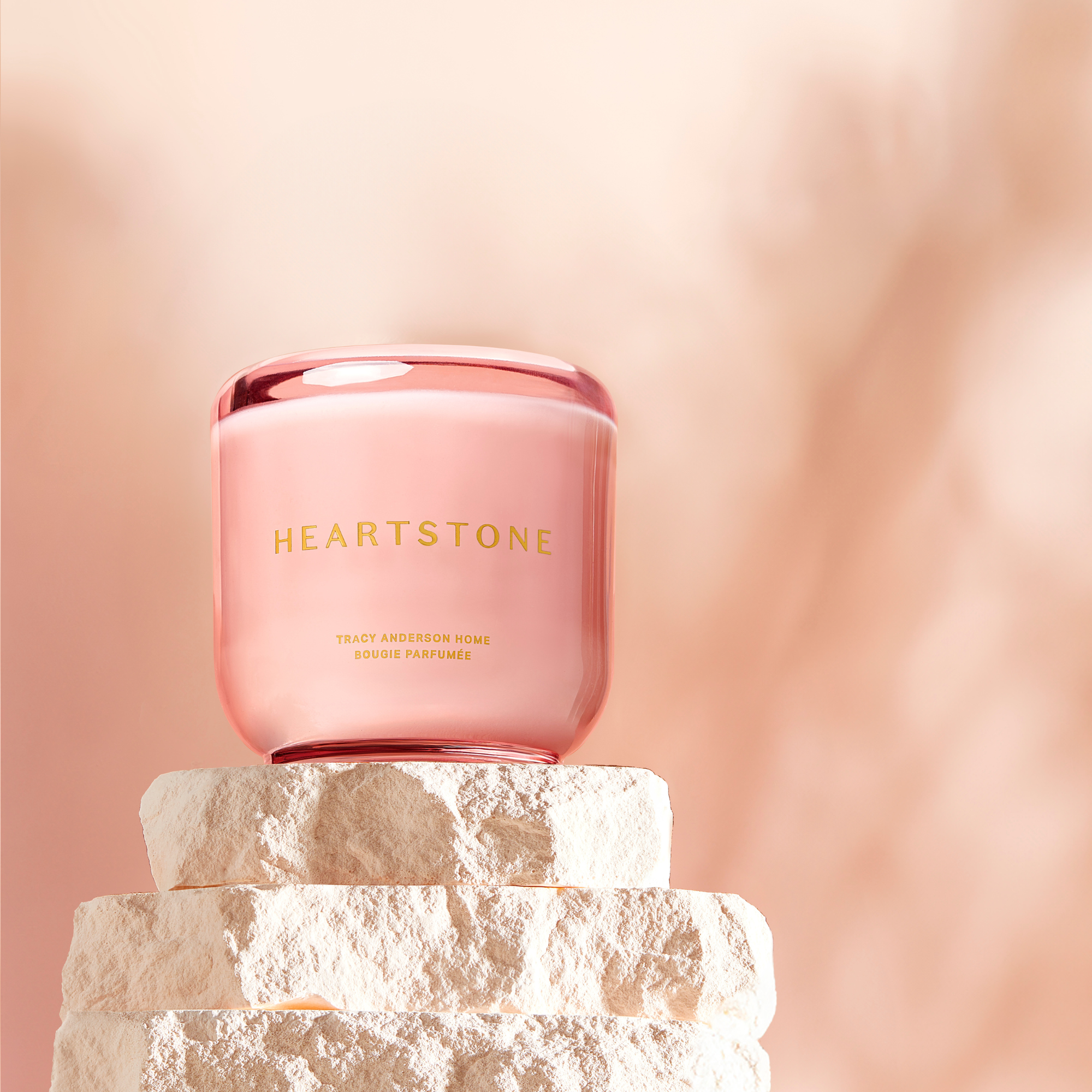 The 6.5 oz HeartStone Scented Candle displayed on a three tiered stone tower.