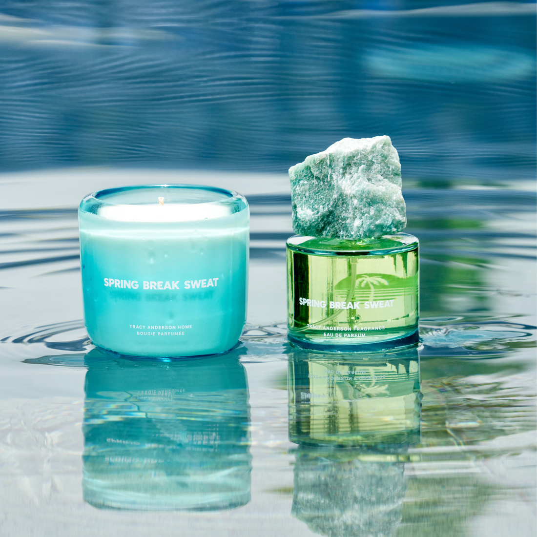 The Tracy Anderson Spring Break Sweat fragrance and candle resting in a glistening pool of water.